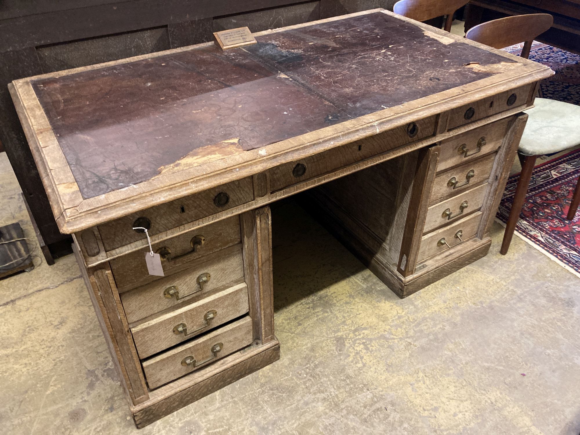 An early 20th century limed oak pedestal desk